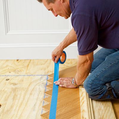 marking the overlap of a herringbone pattern with painter's tape to remove the excess