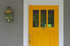 front door with aged light sconce on porch