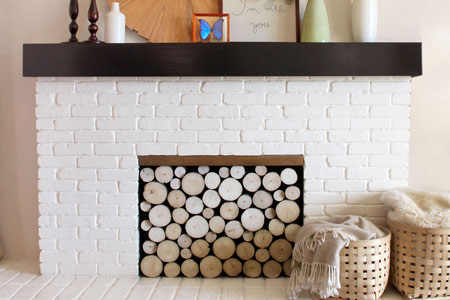 painted white brick fireplace with stacked log imitation summer front