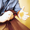man is dabbing woo with cloth and has latex gloves on his hands