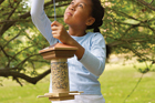 girl hanging handmade bird feeder