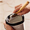 man dipping brush into the bucket of paint