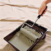 man rolling paintbrush in the paint tray