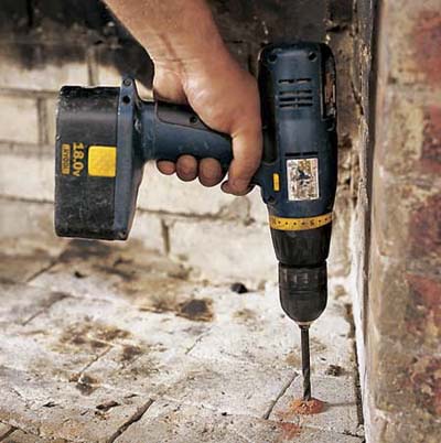 Drilling holes for lead anchors.