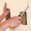 Cutting along pencil lines, using keyhole saw.