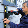 checking for plumb before installing the second screw of a window box bracket