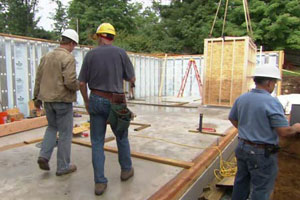 Kevin O'Connor walks along the new basement floor at the Weston house project
