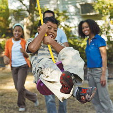 Child swinging on handmade, old-fashioned tree swing
